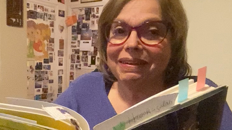 Judith Heumann reading a book smiling