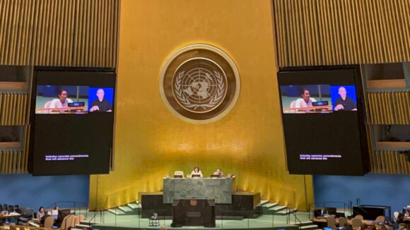 UN general assembly hall with speaker on the screen