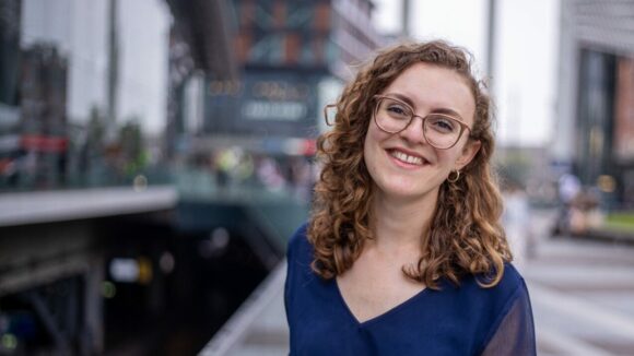 Photo of Lydia smiling in front of Utrecht Central Station.